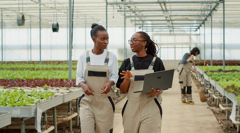 Image of two women walking through greenhouse holding ipad showing technologies in food industry