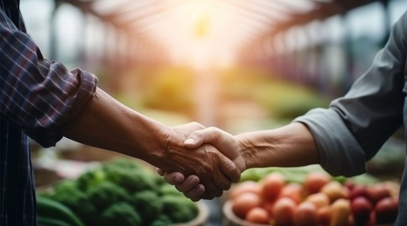 Image of two people shaking hands in a green house full of fresh produce to support food trade industry article