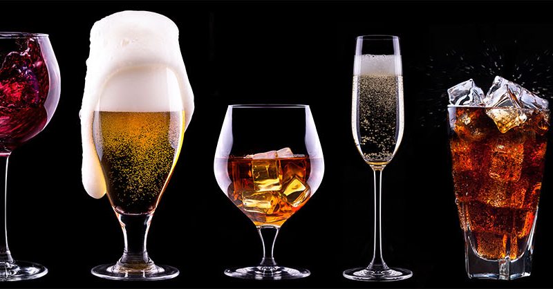 Image of various different alcoholic drinks like wine and beers lined up on a table to support alcohol industry article