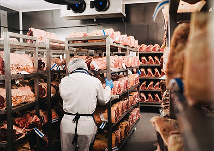 Bitcher moving rack with trays of meat joints on