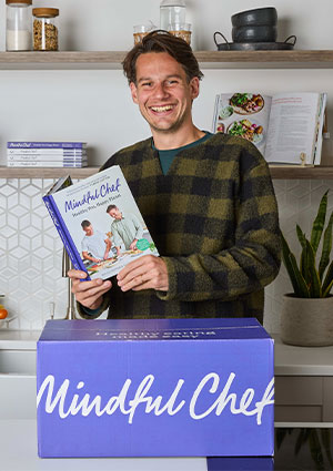 Smiling man with Mindful Chef recipe book