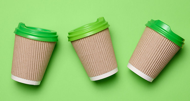Three recyclable mugs on a green background