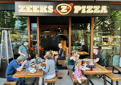 Families eating outside Zeeks Pizza restaurant