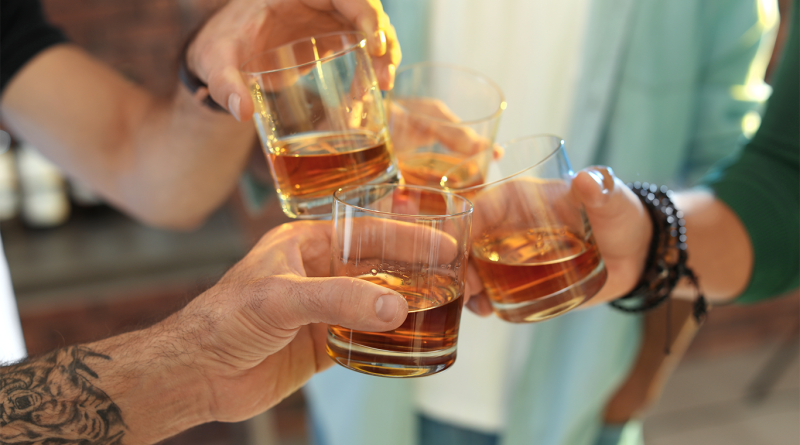 Three people cheers'ing glasses with Bourbon in to support Neat Bourbon Bar article