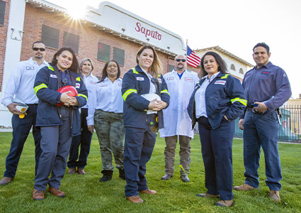 Staff standing on the grass outside a Saputo facility