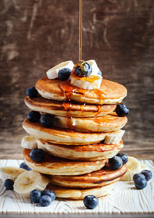 Stack of pancakes with blueberries & sliced banana