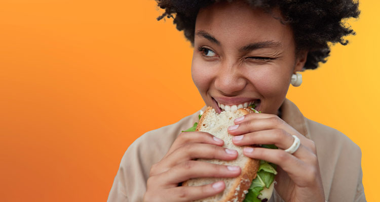 woman feels hungry eats sandwich with appetite