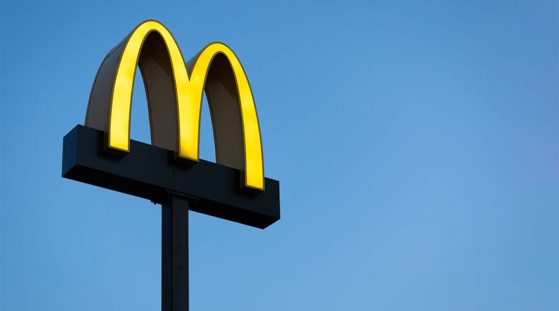 McDonald’s marks 50 years of Egg McMuffin with new Spicy McMuffin McDonald's golden arches logo illuminated against a clear blue sky, mounted on a tall black signpost