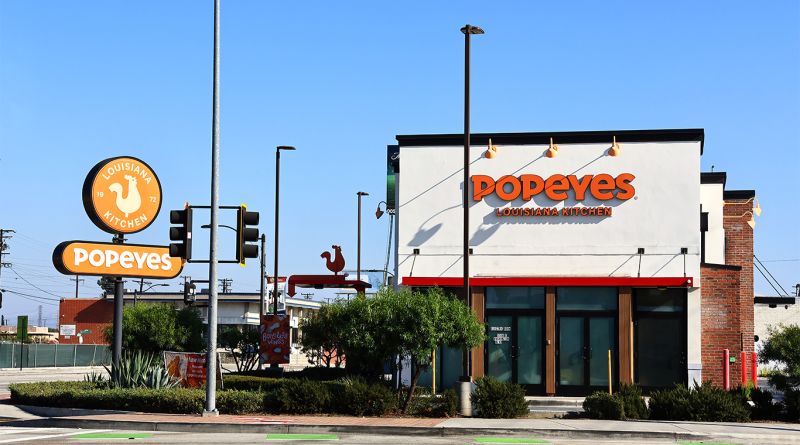 Popeyes Louisiana Kitchen restaurant exterior with branded signage, storefront and roadside sign on a clear day