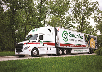 a white Freightliner tractor-trailer branded for Sandridge Crafted Foods