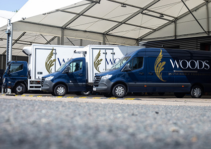  Woods Foodservice delivery vehicles, featuring a custom blue and gold brand wrap
