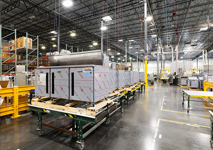 shows the interior of a large, active manufacturing plant or industrial warehouse facility