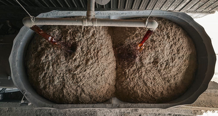 an industrial fermentation vessel or washback filled with a thick grain mash or wort