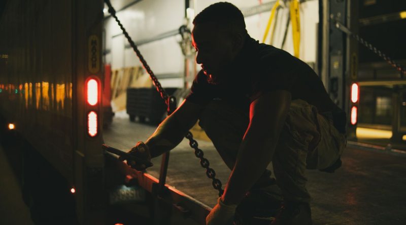 Logistics worker securing cargo inside a refrigerated truck for cold chain delivery.