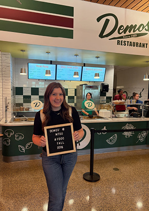  student holding a sign celebrating the grand opening of the new Demos' Restaurant location inside the Student Union Building at Middle Tennessee State University (MTSU) in Murfreesboro, Tennessee