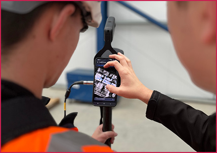         The image appears to show an engineer using an industrial acoustic imaging camera