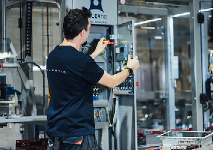  an industrial technician or engineer working on the electrical components of an automated manufacturing machine or control cabinet
